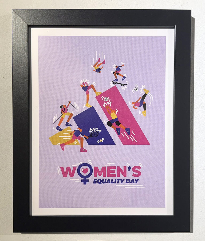 Framed Women’s Equality Day poster featuring colorful stylized women participating in sports and physical activities around bold geometric shapes on a lavender background.
