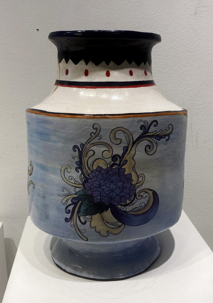 Large blue-and-white ceramic vessel decorated with a purple hydrangea and flowing botanical patterns.