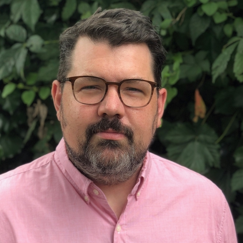 Assistant Professor of Sculpture, Belmont University pictured in pink shirt with salt and pepper beard and brown eye glasses.